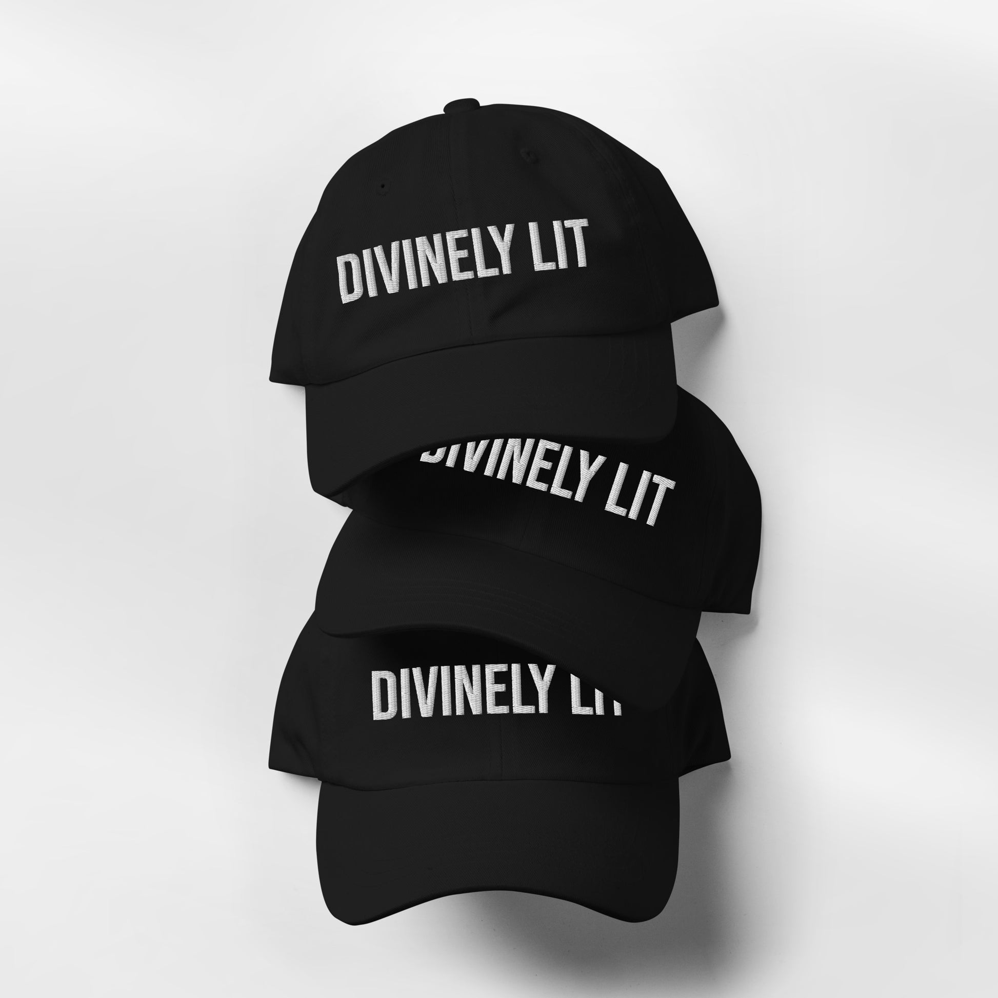 Stacked Black cap with embroidered 'DIVINELY LIT' text on a white background